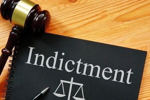 Federal indictment document with gavel and scales of justice. Representative image of the U.S. v. Beauchamp et al. indictment.