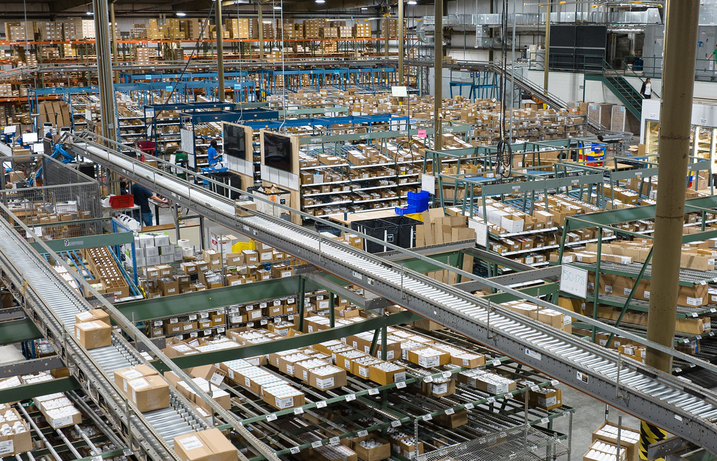Pharmaceutical wholesale distribution center with conveyor lines and pick stations