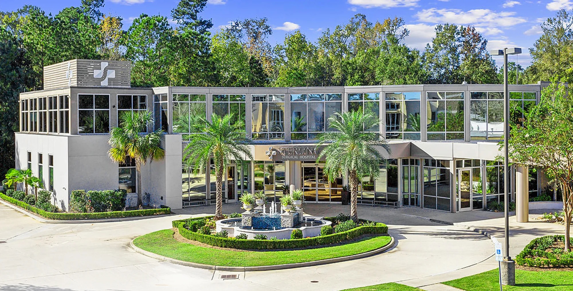 Surgical hospital facility exterior with palm-tree landscaping and circular driveway